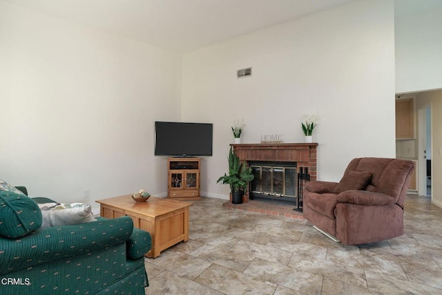 living room featuring a towering ceiling and a brick fireplace