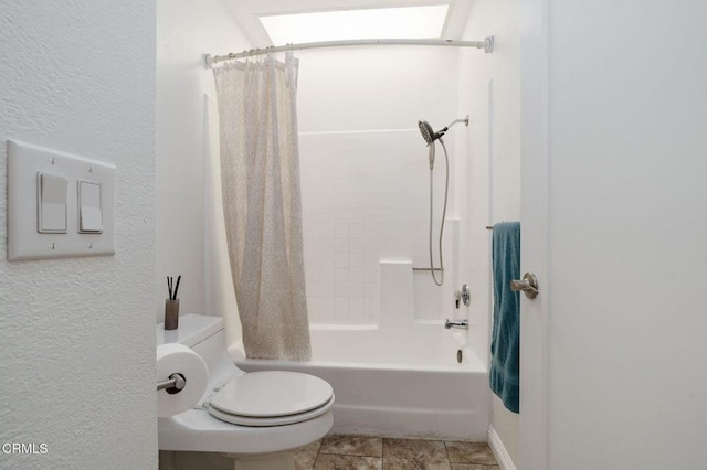 full bathroom with shower / bath combination with curtain, toilet, a textured wall, and a skylight