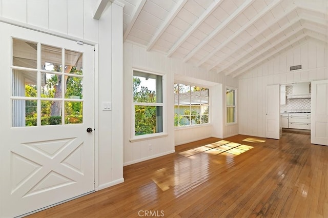 entryway with lofted ceiling with beams, wood-type flooring, and wood walls