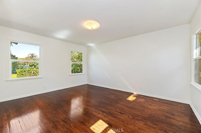 empty room featuring dark hardwood / wood-style floors and plenty of natural light