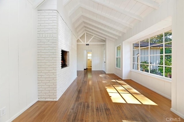 unfurnished sunroom featuring vaulted ceiling with beams and a fireplace