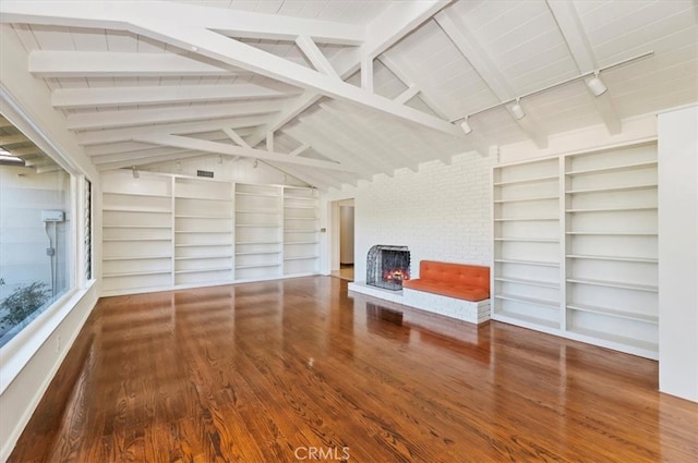 unfurnished living room featuring hardwood / wood-style floors, track lighting, vaulted ceiling with beams, and a fireplace