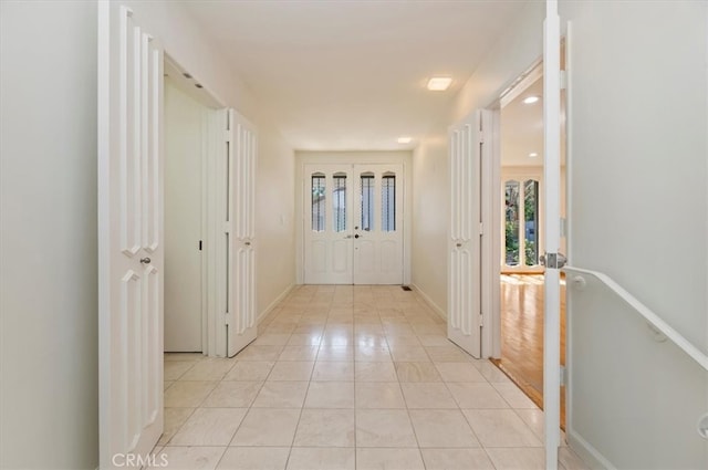 hall with light tile patterned floors