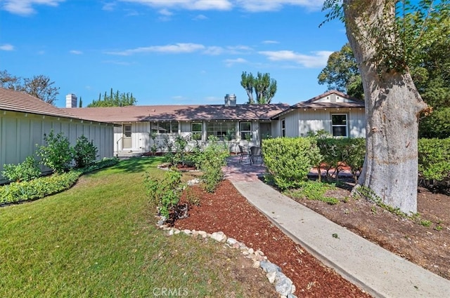 ranch-style house with a patio and a front lawn