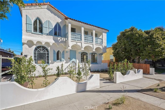 mediterranean / spanish house featuring a balcony