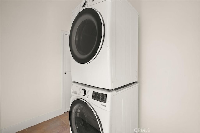 washroom featuring light tile patterned flooring and stacked washer / dryer