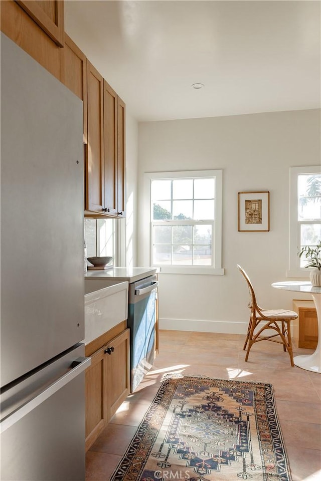 kitchen with stainless steel fridge, plenty of natural light, and light tile patterned floors