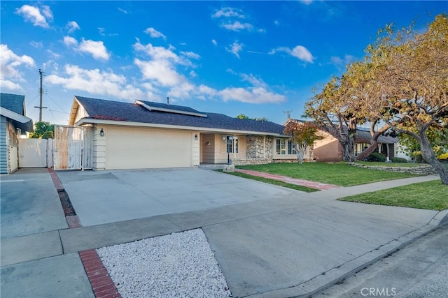 single story home with a garage, a front yard, and solar panels