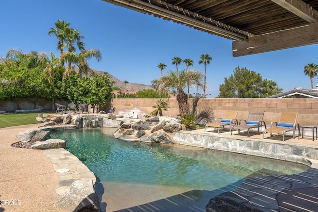 view of swimming pool featuring a patio area, pool water feature, and a mountain view