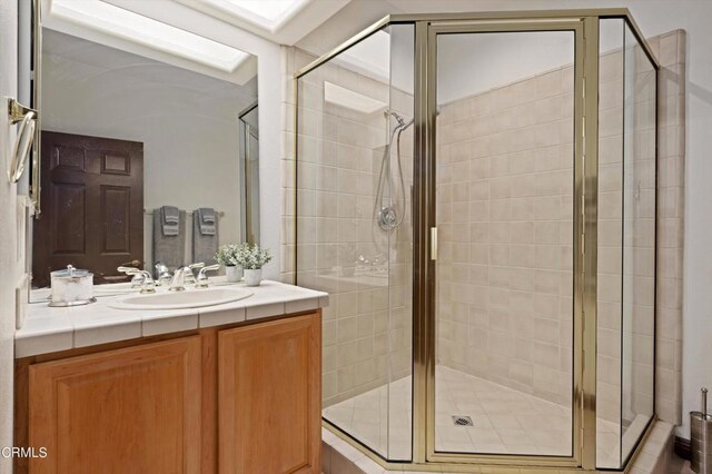 bathroom featuring vanity and a shower with shower door