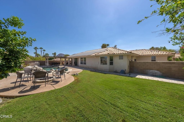 back of property with a yard and a patio