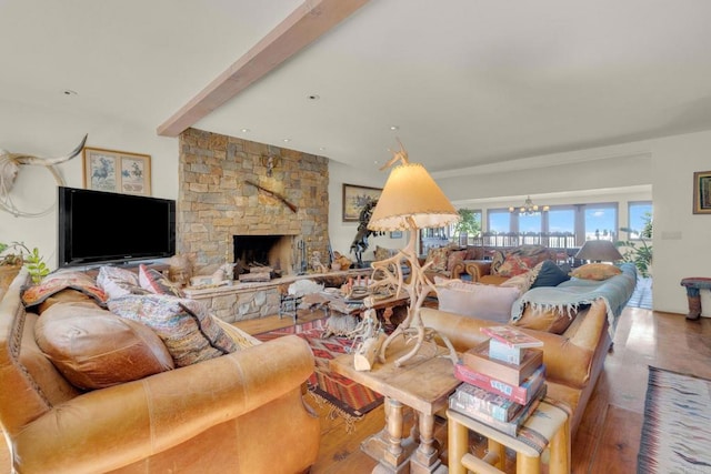 living room featuring beamed ceiling, a chandelier, a stone fireplace, and wood-type flooring