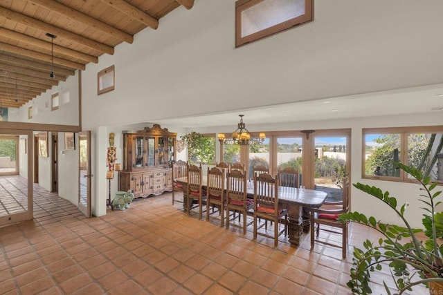 tiled dining area with beam ceiling, high vaulted ceiling, a chandelier, and wood ceiling