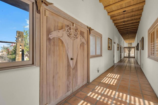 corridor featuring beam ceiling, wooden ceiling, and light tile patterned flooring