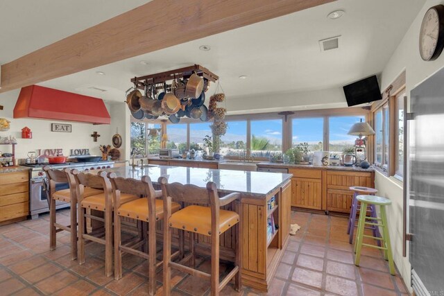 kitchen featuring a wealth of natural light, appliances with stainless steel finishes, light tile patterned floors, and extractor fan