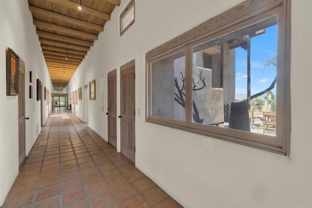 hallway featuring a wealth of natural light, vaulted ceiling with beams, a mountain view, and wooden ceiling