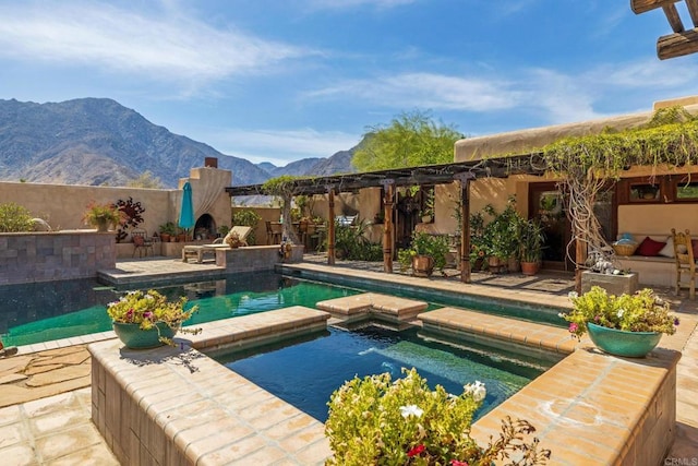 view of swimming pool with an in ground hot tub, a mountain view, and a patio area