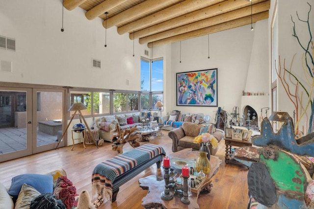 living room featuring french doors, beam ceiling, hardwood / wood-style flooring, and a high ceiling