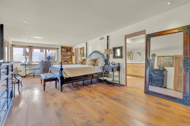 bedroom with light hardwood / wood-style flooring and connected bathroom