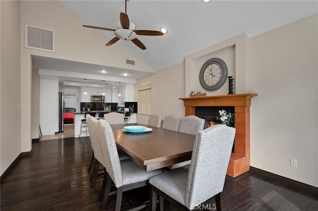 dining space featuring ceiling fan, dark hardwood / wood-style flooring, and high vaulted ceiling