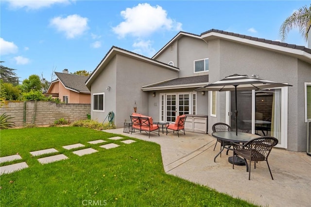 back of house with a yard and a patio