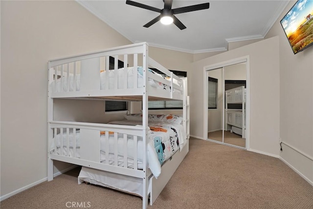 carpeted bedroom featuring ceiling fan, a closet, and ornamental molding