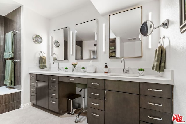 bathroom featuring tiled bath and vanity