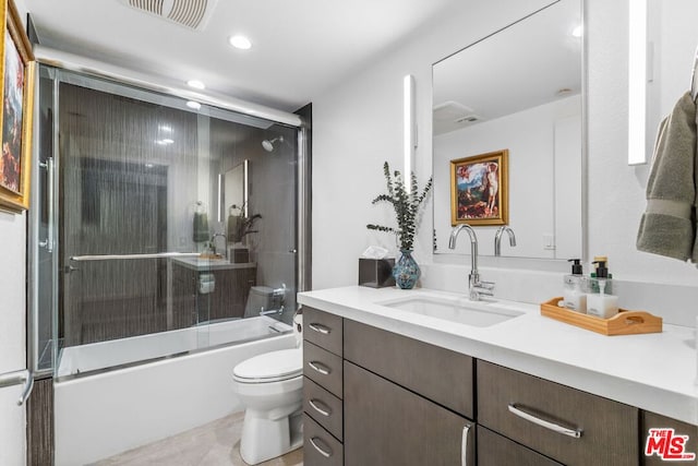 full bathroom featuring toilet, enclosed tub / shower combo, tile patterned flooring, and vanity