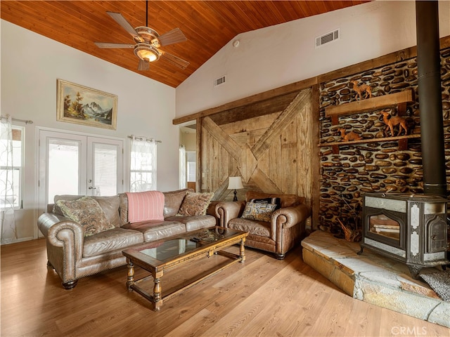 living room featuring hardwood / wood-style flooring, high vaulted ceiling, a wood stove, and wooden ceiling