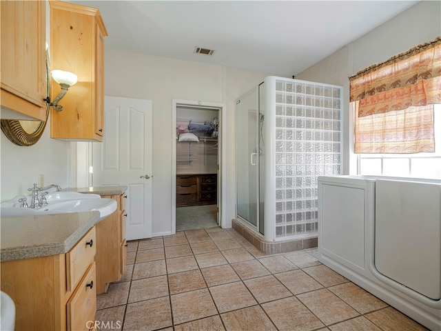 bathroom featuring vanity, tile patterned floors, and walk in shower