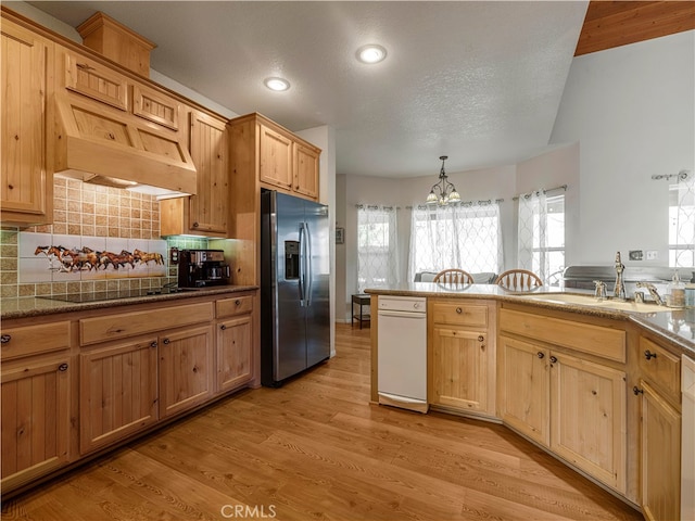 kitchen featuring stainless steel fridge with ice dispenser, black electric cooktop, pendant lighting, light hardwood / wood-style floors, and sink