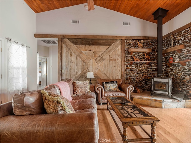 living room featuring wood ceiling, beam ceiling, high vaulted ceiling, wood-type flooring, and a wood stove