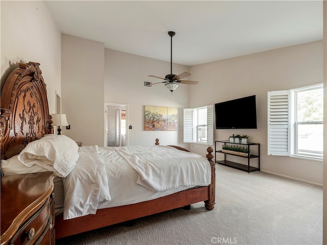 carpeted bedroom featuring multiple windows and ceiling fan