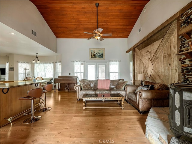 living room featuring ceiling fan with notable chandelier, high vaulted ceiling, light wood-type flooring, and wooden ceiling