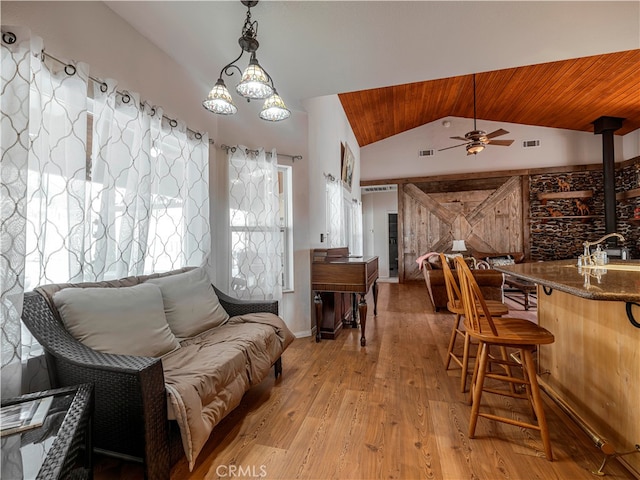 interior space with lofted ceiling, light hardwood / wood-style flooring, wood ceiling, and ceiling fan