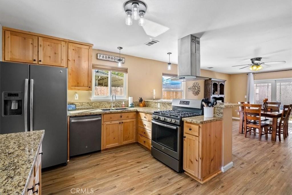 kitchen with ceiling fan, light wood-type flooring, island range hood, kitchen peninsula, and stainless steel appliances