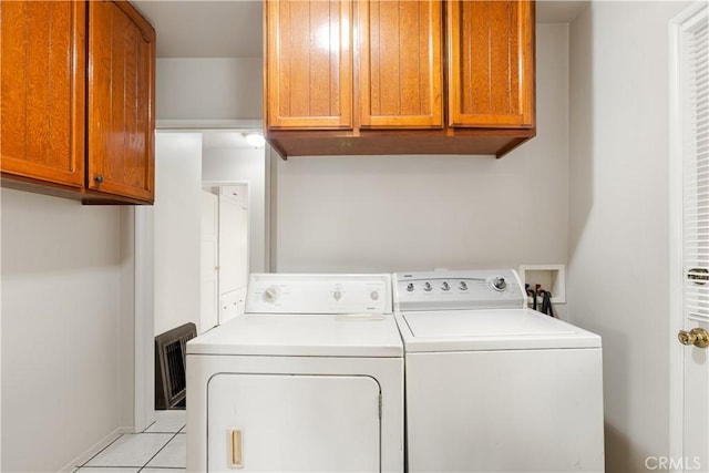 laundry area featuring cabinets, light tile patterned floors, and separate washer and dryer