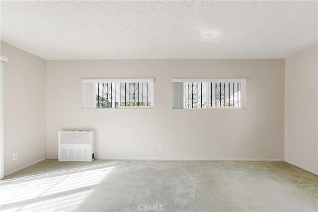 carpeted empty room with a textured ceiling