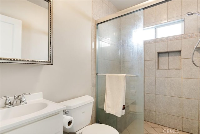 bathroom with toilet, tile patterned flooring, a shower with door, and vanity