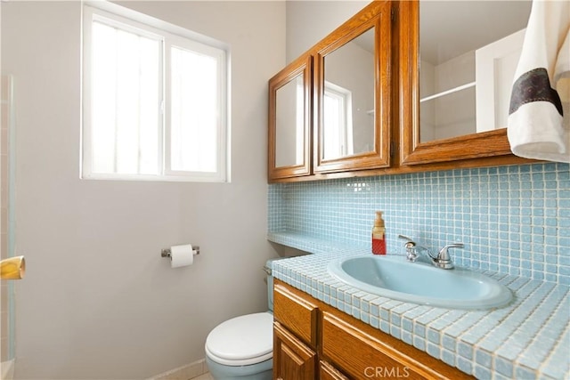 bathroom featuring tasteful backsplash, vanity, and toilet