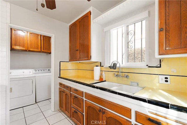 kitchen with light tile patterned floors, ceiling fan, decorative backsplash, separate washer and dryer, and sink