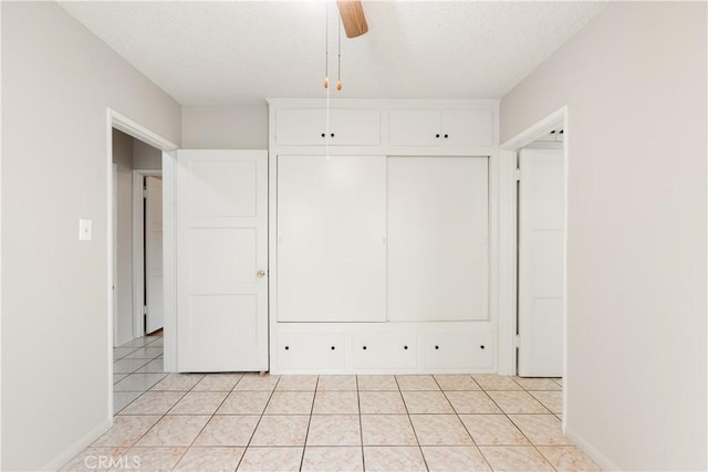 unfurnished bedroom featuring ceiling fan and light tile patterned flooring