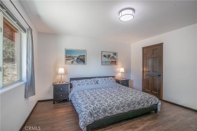 bedroom with dark wood-type flooring and multiple windows