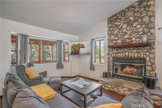 living room featuring a healthy amount of sunlight, hardwood / wood-style flooring, a fireplace, and vaulted ceiling