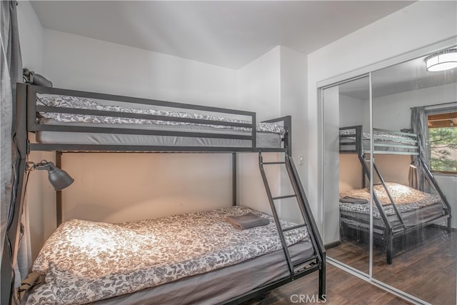 bedroom with a closet and dark hardwood / wood-style flooring