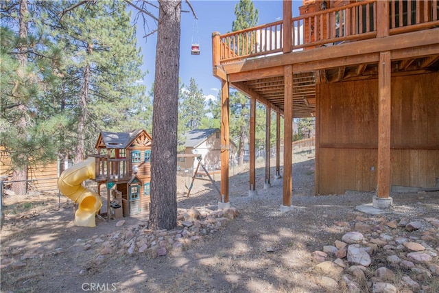 view of yard featuring a deck and a playground