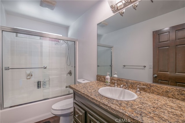 full bathroom featuring vanity, bath / shower combo with glass door, wood-type flooring, and toilet