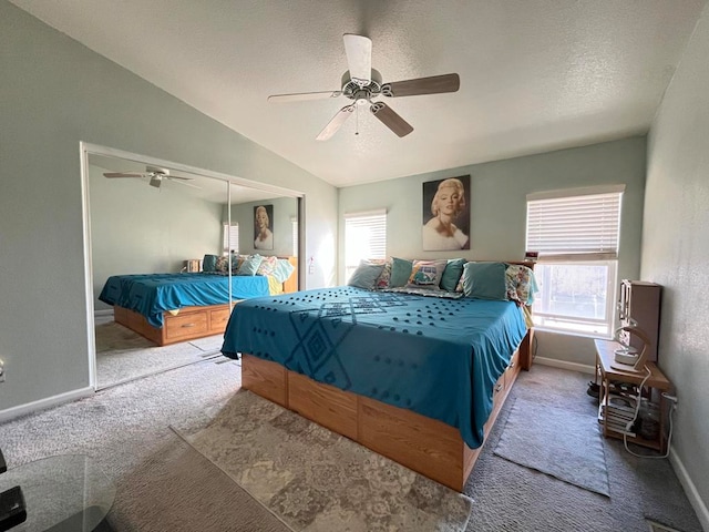 carpeted bedroom with a closet, a textured ceiling, lofted ceiling, and ceiling fan