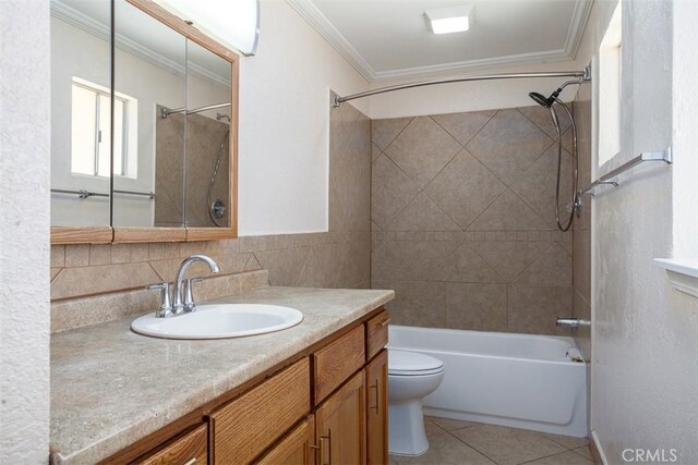 full bathroom with tile patterned floors, toilet, crown molding, tiled shower / bath combo, and vanity