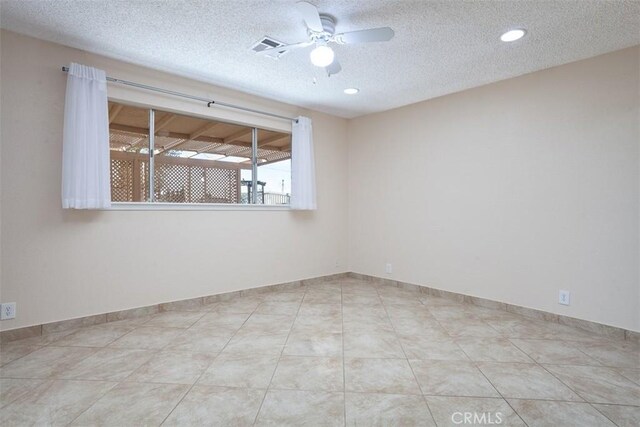 tiled spare room featuring a textured ceiling and ceiling fan